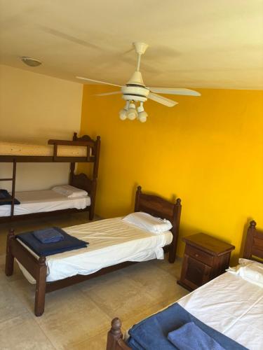 a room with three bunk beds and a ceiling fan at A carlos paz voy in Villa Carlos Paz