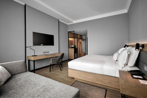 a bedroom with a bed and a desk and a tv at AC Hotel by Marriott Kuala Lumpur in Kuala Lumpur