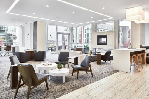 a lobby with chairs and tables and a living room at AC Hotel National Harbor Washington, DC Area in National Harbor