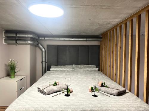 una camera da letto con un letto con due bicchieri e fiori sopra di Zarembowicza Apt 52 - Self Check-In 20h - Lift a Breslavia