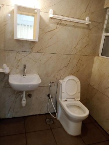 a bathroom with a toilet and a sink at Kamadhenu Residency Homestay & Service Apartment Coorg Madikeri in Madikeri