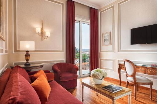 a living room with a red couch and a table at Sina Villa Medici, Autograph Collection in Florence