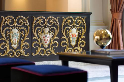 a black headboard with masks on it next to a table at Sina Villa Medici, Autograph Collection in Florence