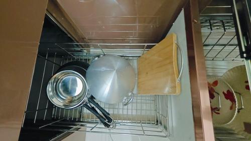 a kitchen utensil and a pot in an oven at Bamboo Stays Posh 2bhk with Sky Garden in Pune