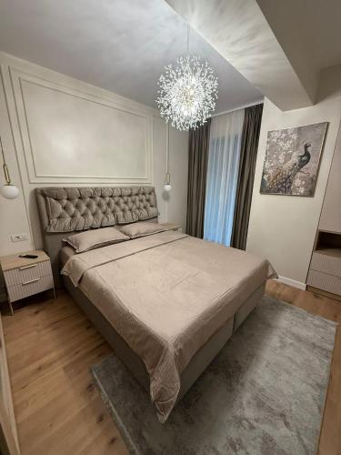 a bedroom with a large bed and a chandelier at Sole Central Apartment in Râmnicu Vâlcea