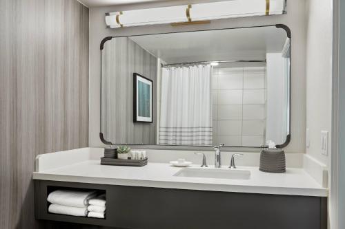 a bathroom with a sink and a large mirror at Westdrift Manhattan Beach, Autograph Collection in Manhattan Beach