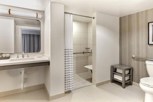 a bathroom with a toilet and a sink and a shower at Westdrift Manhattan Beach, Autograph Collection in Manhattan Beach