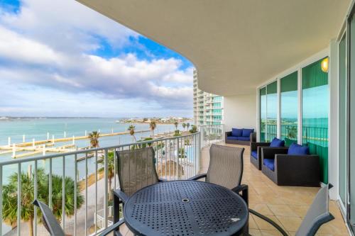 a balcony with a table and chairs and a view of the ocean at Caribe 306 C in Orange Beach