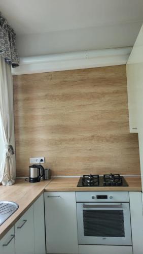 a kitchen with a stove and a wooden wall at City Park Appartement in Nitra