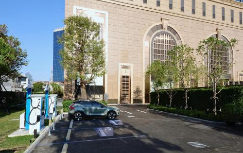 a car parked in a parking lot in front of a building at Grande Centre Point Lumphini Bangkok in Bangkok