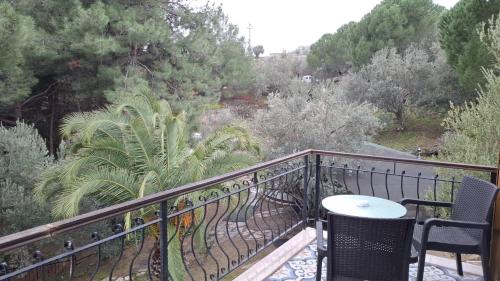 a balcony with a table and chairs and trees at Dusler Vadisi Kazdaglari in Edremit