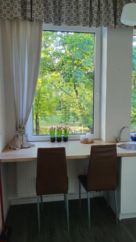 a kitchen counter with two chairs in front of a window at City Park Appartement in Nitra
