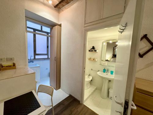 Un baño blanco con lavabo e inodoro. en Suite Termini - Cozy suite few steps from Termini station, en Roma
