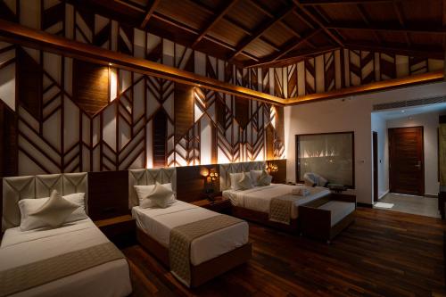 Una habitación de hotel con dos camas y un televisor. en The Eden, en Port Blair