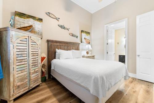 a bedroom with a white bed and a wooden dresser at Spanish Key 702 in Perdido Key