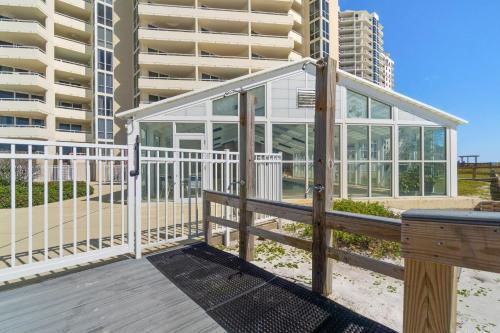 a glassconservatory on a deck in front of a building at Perdido Sun 304 in Perdido Key