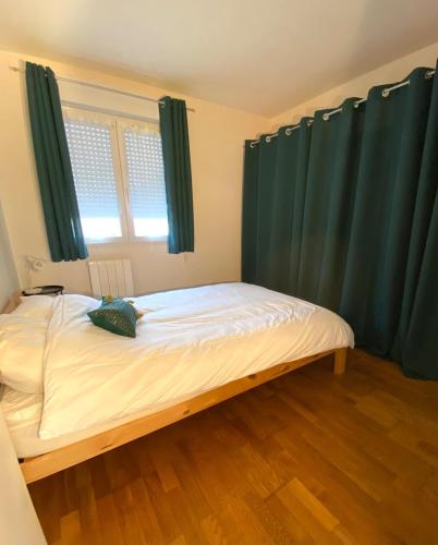 - une chambre avec un lit et des rideaux verts dans l'établissement Apartment St Jean de la Ruelle, à Saint-Jean-de-la-Ruelle