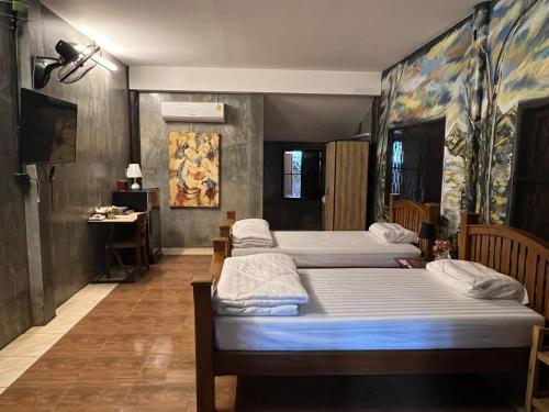 a room with four beds and a desk in it at The Bodhi House in Chiang Mai