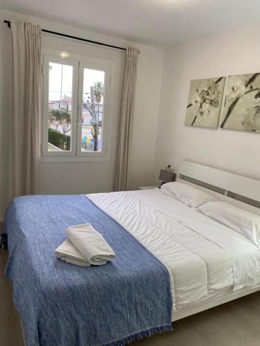 a bedroom with a white bed and a window at YourHouse Llimonera in Port de Pollensa