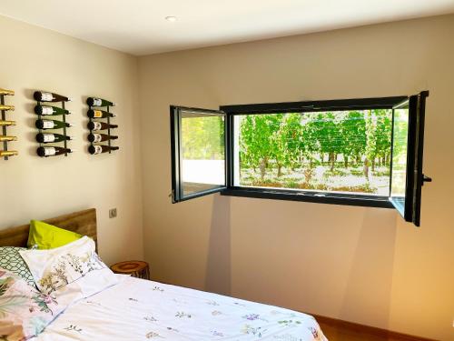 a bedroom with a bed and a window at La Chambre aux Bouteilles - Domaine GUETH - Vins d'Alsace et oenotourisme in Gueberschwihr