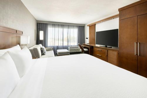 a hotel room with a bed and a flat screen tv at Courtyard by Marriott Los Angeles Woodland Hills in Woodland Hills