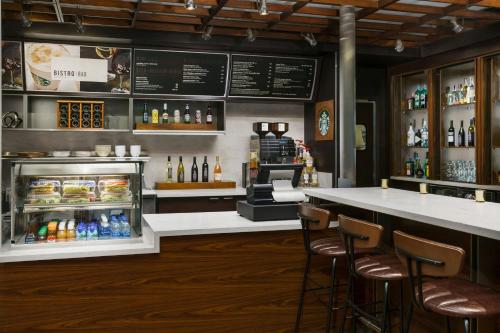 a restaurant with a counter and a bar with chairs at Courtyard by Marriott Los Angeles Woodland Hills in Woodland Hills