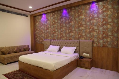 a bedroom with a bed and a couch at Lotus Resort in Raipur