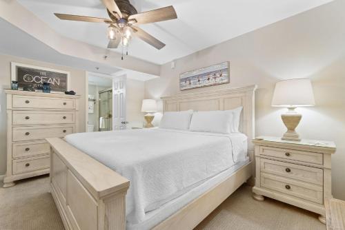 a bedroom with a white bed and a ceiling fan at Phoenix VII 907 in Orange Beach