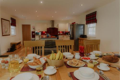 ein Tisch mit Tellern und Schüsseln mit Essen darauf in der Unterkunft Sherrabeg Cottage in Laggan