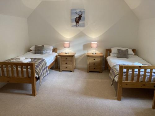 1 Schlafzimmer mit 2 Einzelbetten und 2 Nachttischen in der Unterkunft Sherrabeg Cottage in Laggan