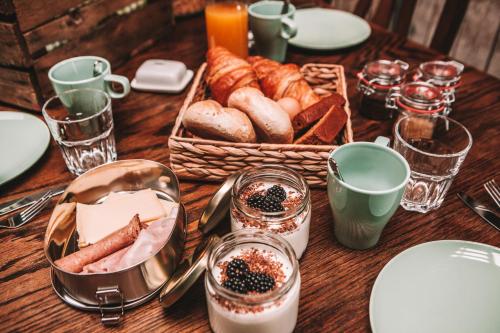 a table topped with a basket of bread and pastries at CRASH'NSTAY - Wachtpost 20 in Waspik