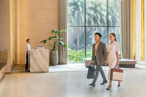 a man and a woman walking through a lobby at Sheraton Can Tho in Can Tho