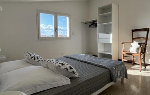 une chambre avec un lit avec une chaise et une fenêtre dans l'établissement Maison individuelle familiale face à l'étang 6GLYC25, au Barcarès