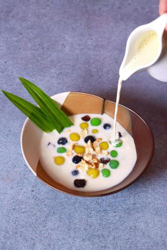 a bowl of yogurt with a white spoon in it at Sheraton Can Tho in Can Tho