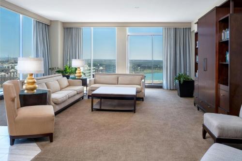 a living room with couches and chairs and windows at Renaissance Dallas North Hotel in Dallas