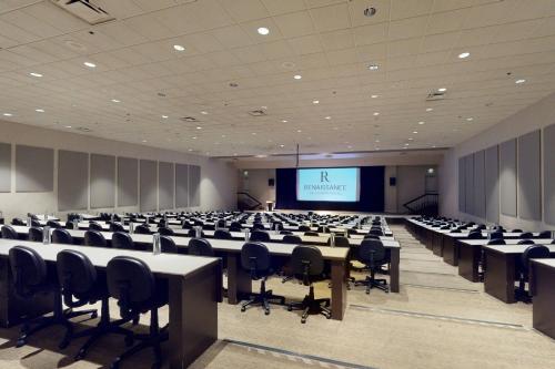 a large room with desks and chairs and a screen at Renaissance Dallas North Hotel in Dallas