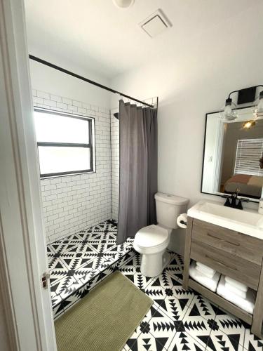 a bathroom with a toilet and a sink and a mirror at Courthouse Corner - Beautiful adobe, pet friendly in Marfa