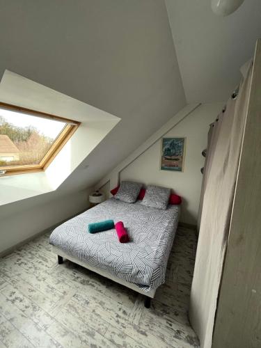 une chambre avec un lit dans un grenier dans l'établissement Maison proche Circuit des 24h, à Ruaudin