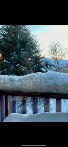 a pile of snow on a wooden fence at Chalet entier dans le domaîne skiable Pla d'Adet in Saint-Lary-Soulan