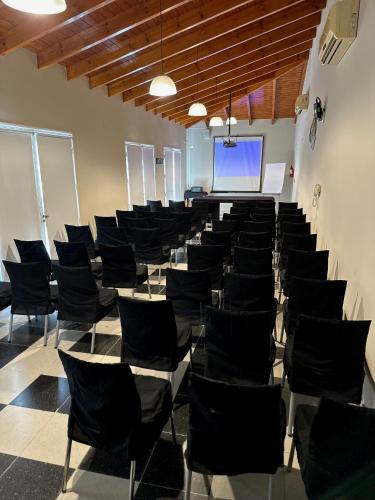a room with chairs and a screen in a room at Garden House Hotel in Río Cuarto