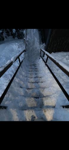 a snow covered path with two benches in the snow at Chalet entier dans le domaîne skiable Pla d'Adet in Saint-Lary-Soulan