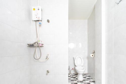 a white bathroom with a toilet and a shower at Tom Guest House ทอมส์ เกสต์เฮ้าส์ in Thung Maha Mek