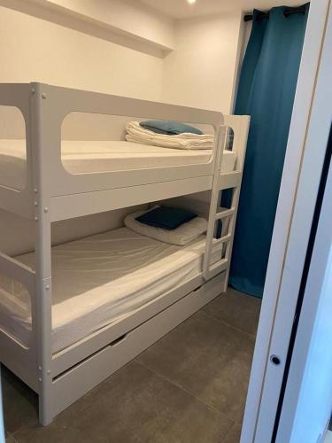- un lit superposé blanc avec quelques serviettes dans l'établissement Appartement MIRAMAR 6 couchages, à Cannes