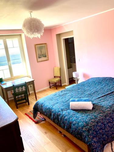 a bedroom with a bed with a blue blanket and a desk at Longère 12 couchages Ploubalay in Ploubalay