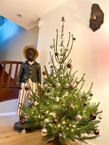 a christmas tree with a statue next to it at Longère 12 couchages Ploubalay in Ploubalay
