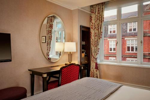 a hotel room with a desk and a window at St. Ermin's Hotel, Autograph Collection in London
