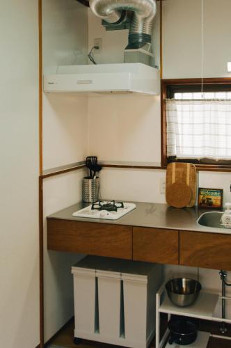 a small kitchen with a stove and a sink at 春日舎 KASUGASYA-Kyoto in Kyoto