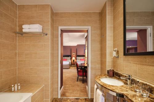 a bathroom with two sinks and a room with a bedroom at St. Ermin's Hotel, Autograph Collection in London