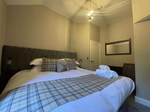 a bedroom with a large bed with towels on it at Greta House in Keswick
