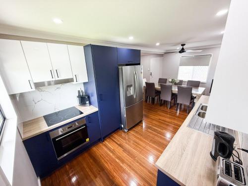 a kitchen with blue and white cabinets and a dining room at Chic Retreat Vintage and Modern in Garbutt Station